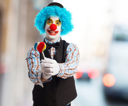 portrait of a funny clown holding a lollipop