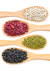 Job's tears, Kidney beans, Mung beans and Black beans with wooden spoon isolated on white.