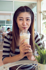 happy women drinking frappe coffee in cafe