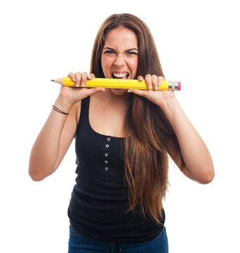 young woman biting a big pencil
