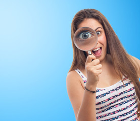 portrait of a young woman looking through a magnifying glass