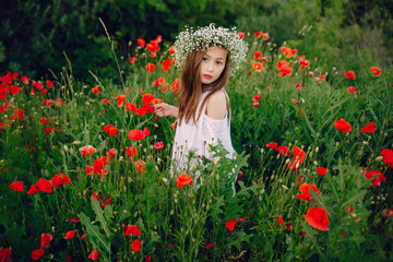 Naklejka premium beautiful little girl posing in a skirt wreath of poppies