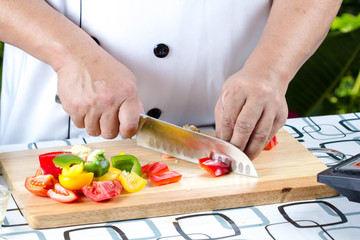 Chef cutting tomato