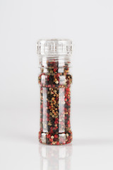 Colored Peppers Mix and pepper grinder on white background