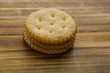 a pile of three biscuits over wooden background