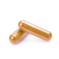 Turmeric powder inside a capsule isolated on white
