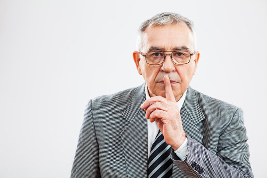 Portrait of senior businessman who wants silence