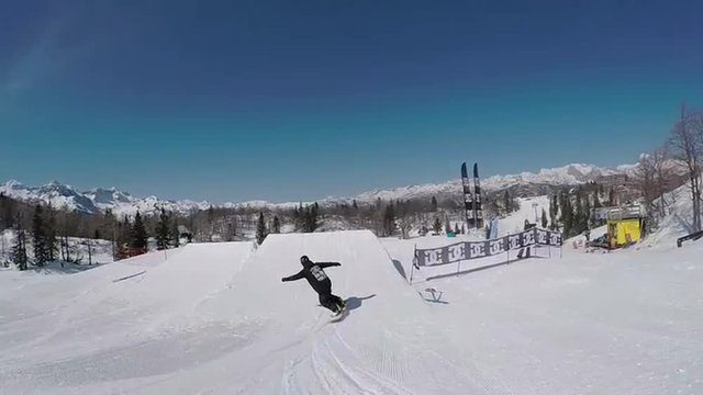 SLOW MOTION: Snowboarder jumping over big air kicker