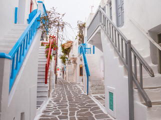 Mykonos town streetview with stairs and blue and grey and red banisters, Greece

