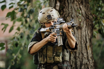 Fototapeta premium Soldier aiming his rifle on battlefield background