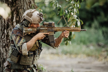 Soldier aiming his rifle on battlefield background