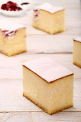 Cheesecake with cherries on white wooden background