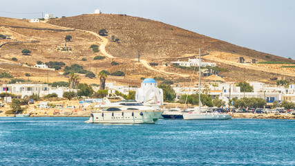 Antiparos port in Greece with a traditional white church standing in the middle.
