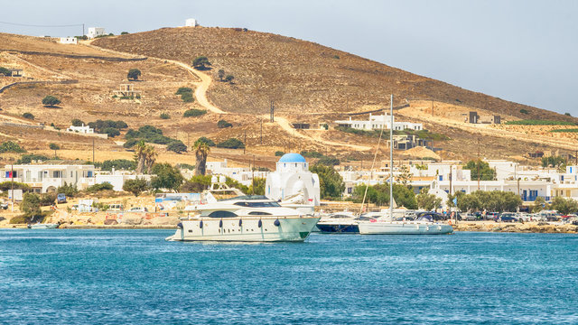 Antiparos port in Greece with a traditional white church standing in the middle.

