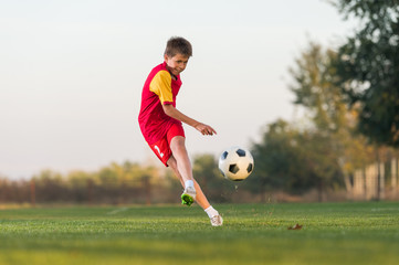 kid kicking a soccer ball
