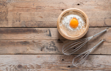 Egg yolk in the flour and whip for beating on wood table. Top vi
