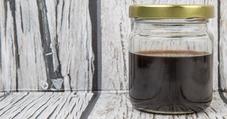 Balsamic vinegar in a mason jar over rustic wooden background