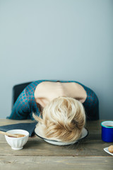 tired and exhausted lady puts her head into her plate