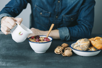 young hipster man having a breakfast on dark table