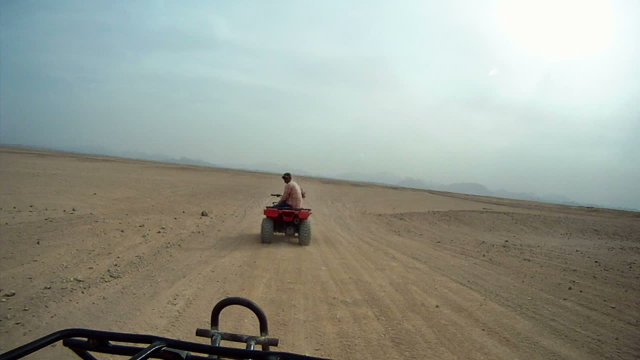 Driving quadbike trough the desert
