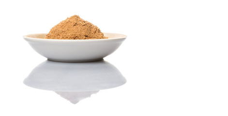 Dried galangal powder in white bowl over white background