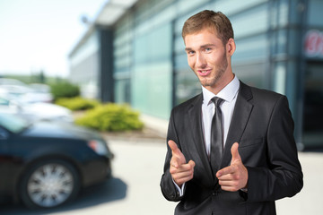 Young handsome businessman pointing on you