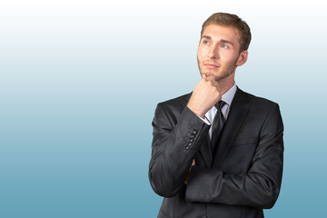 Confused young businessman thinking