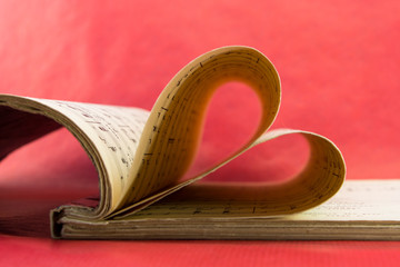 Music notation book with pages shaping heart closeup