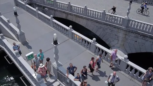 AERIAL: Boat cruising under the triple bridge