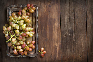 Grapes on silver tray on an Wooden Background