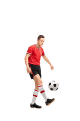 Young male football player juggling a ball