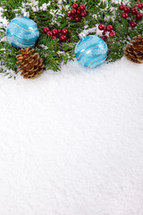 Christmas border with decorations on the snow and copy space