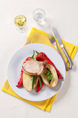 Roasted pork chop with  potato and red peppers