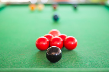 Close up of black snooker ball on the table with many snooker ball background