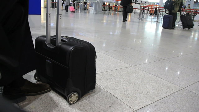 Black luggage case at an airport departure hall