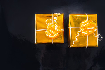 Gold foil wrapped Christmas gifts on black