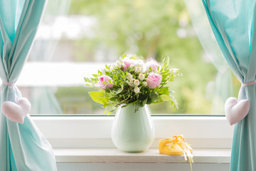 beautiful bouquet and yellow small baby shoe on a window sill © very_ulissa