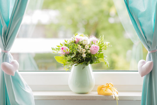 beautiful bouquet and yellow small baby shoe on a window sill