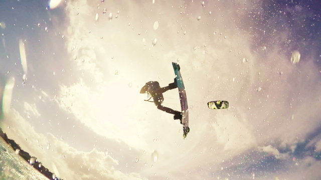 Young Man Jumps Huge Over Camera Kitesurfing in Ocean. Extreme Summer Sport HD. Slow Motion.