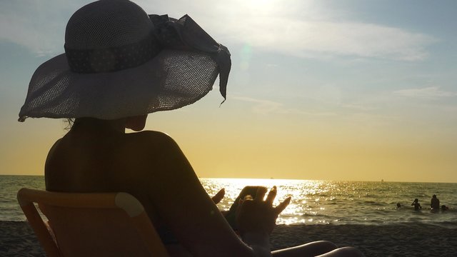 Sea sunset with young woman with sun 