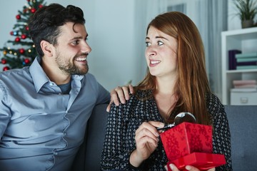 girlfriend looks sceptical to her christmas gift