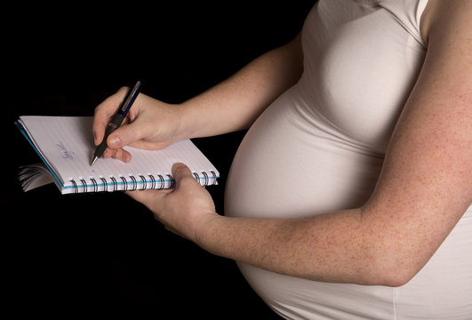 Pregnant women writing a baby list
