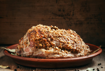 Delicious baked ham pork on a clay tray on the old wooden backgr