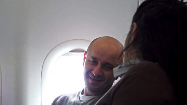 Happy couple travelling by plane together talking 