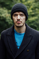 young man with black hat in forest