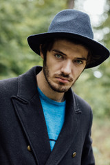 young man with black hat in forest