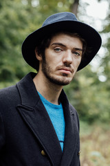 young man with black hat in forest
