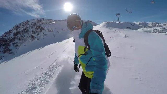 Snowboarder riding powder off piste in ski resort