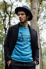 young man with black hat in forest