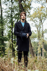 young man with black hat in forest